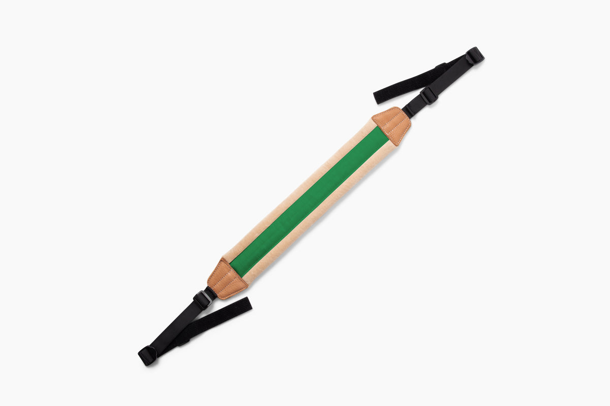 A wooden walking stick with a natural wood finish, a vibrant green center stripe, and black adjustable webbing straps at both ends, shown on a plain white background.